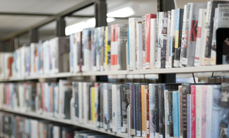 Rows of colorful books on shelves in a well-lit library in West Hartford, CT.