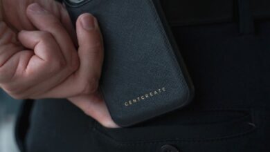 Close-up of a man holding a smartphone with a luxury case indoors.