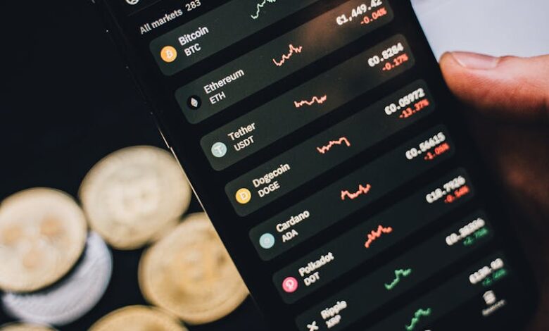 Close-up of a smartphone showing cryptocurrency trends with coins in the background.