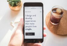 person holding space gray iPhone 6 displaying i design and develop experiences that make people's lives simple text