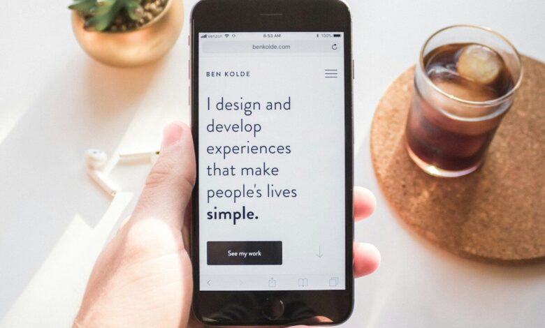person holding space gray iPhone 6 displaying i design and develop experiences that make people's lives simple text