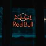 a red bull sign is lit up in the dark