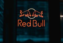 a red bull sign is lit up in the dark