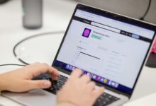 Person typing on a laptop computer screen.