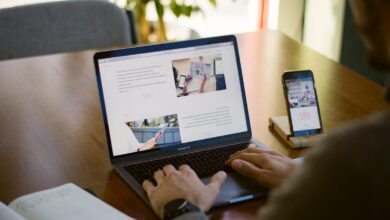 person sitting near chain while using MacBook Pro