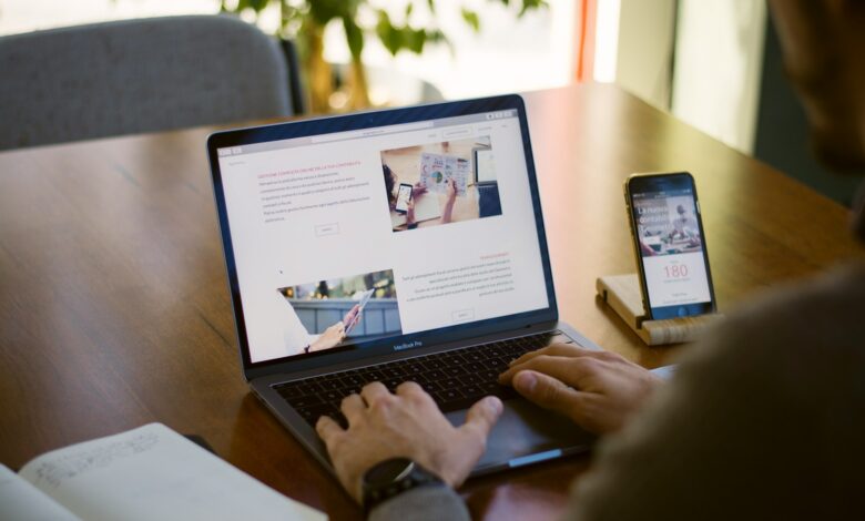 person sitting near chain while using MacBook Pro