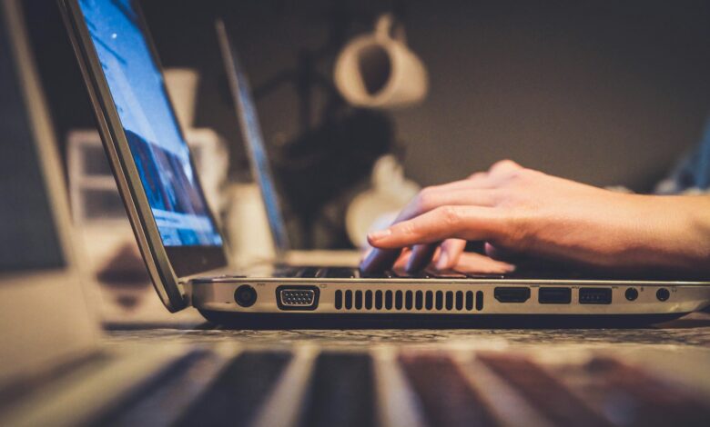 person using silver laptop computer on desk