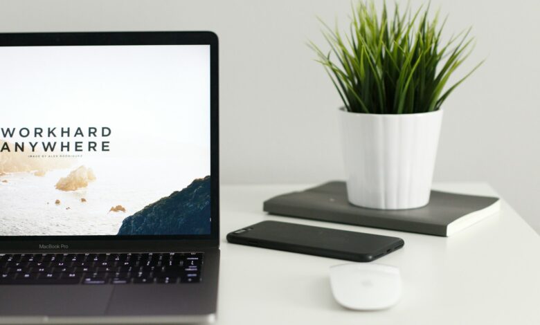 MacBook Pro near green potted plant on table